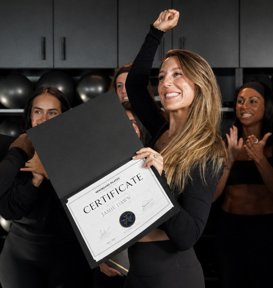 Newly certified HEROBOARD instructor holding her certificate